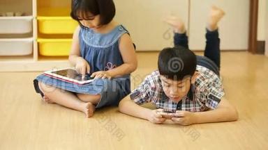 一群小亚洲孩子吃零食，一起玩电脑平板电脑。